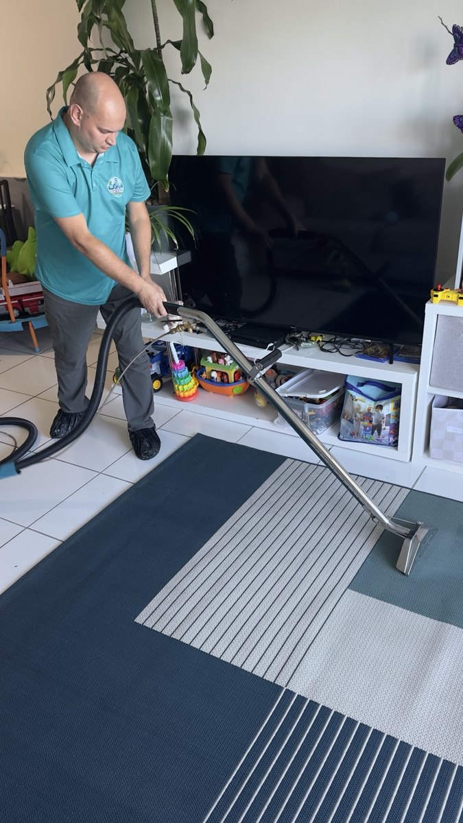 Cleaning an area rug with a long carpet wand